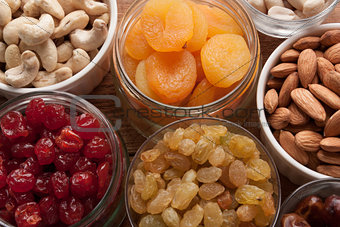 Nuts and dried fruits assortment in jars and bowls.