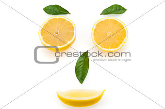 Bright lemon slices and green leaves in the form of a face. The concept of a healthy lifestyle.
