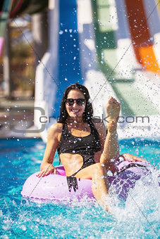 smiling lady in bikini sitting in the pool on rubber ring