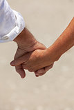 Happy Senior Couple Holding Hands on a Beach