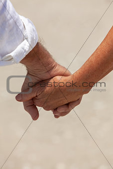 Happy Senior Couple Holding Hands on a Beach