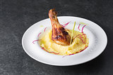 Mashed potatoes with chicken leg appetizing on a white plate