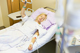 Bedridden female patient recovering after surgery in hospital care.