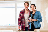 Portrait of a happy young couple holding tools for home remodeling