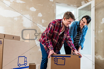 Young couple opening boxes during renovation of new home