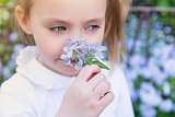 Girl child sniffing flowers, close-up