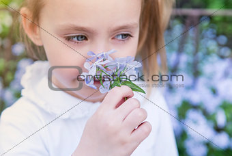 Girl child sniffing flowers, close-up