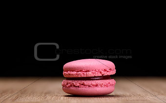 Pink macaroon on wooden background