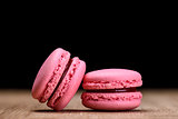 Two pink macaroons on wooden background