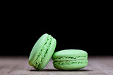 Two green macaroons on wooden table