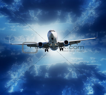 Airplane flying on stormy cloudy sky background
