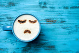 cup of cappuccino with a sad face