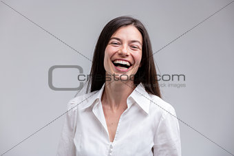 Young cheerful brunette woman in white shirt
