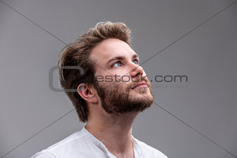 Young man looking up while thinking of a new idea
