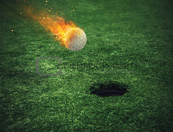 Fiery golf ball near the hole in a grass field