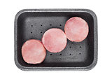 Raw round pork steak slices in plastic tray