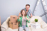 Young married couple with boxes and holding flat keys.