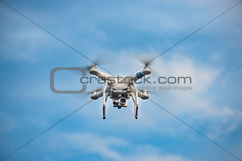 White Drone with Camera Flying in Blue Sky. UAV Concept