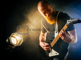 Guitar player in front of spotlight