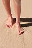 Feet on sandy beach