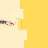 Decorator painting a wall with a paint roller
