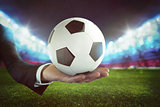 Sport bets. Soccer ball on the hand of a businessman with stadium background