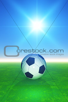 3D football on grassy pitcch against sunny blue sky