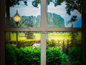 Classic cozy white window and a green forest view with a light in the shadows in a colorful landscape