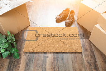 Blank Welcome Mat, Moving Boxes, Shoes and Plant on Hard Wood Fl