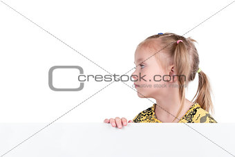 Girl looks sideways from behind the board