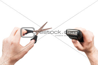 Scissors and electric razor in the hands