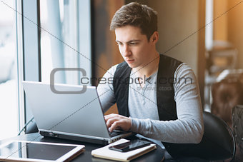 Young man with pc computer at cafe