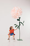 Big flower and little girl in red on white background