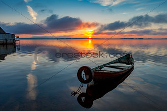 Sunrise on Lake Seliger with an old boat in the foreground.