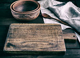  empty brown wooden cutting board with handle and empty ceramic 