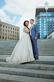 young beautiful bride wonan and groom man outdoor on background of city