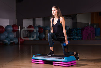 Sporty woman practice on step platform in gym