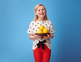 smiling modern girl showing plate with lemons on blue