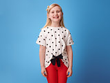 Portrait of smiling modern child in red pants on blue