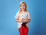 sad modern child in red pants on blue with abdominal pain