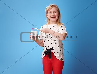 happy modern girl brushing tooth with toothbrush on blue