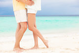 legs of young hugging couple in love on tropical turquoise beach
