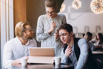Three Businesspeople Working In cafe