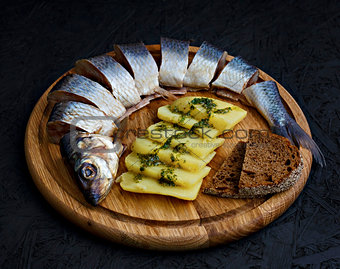 Salted herring with boiled potatoes and green sauce.