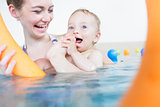 Mothers being happy about their babies playing with each other in pool