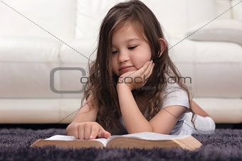 Little Girl Reading Bible on Carpet