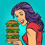 giant Burger. Hungry woman eating fast food