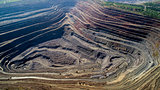 Aerial view of opencast mining quarry with lots of machinery at work.
