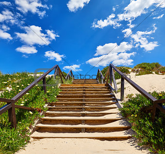 Wooden stairs with railing at beach buried
