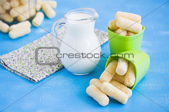 Milk jug and sweet corn sticks with sugar powder.